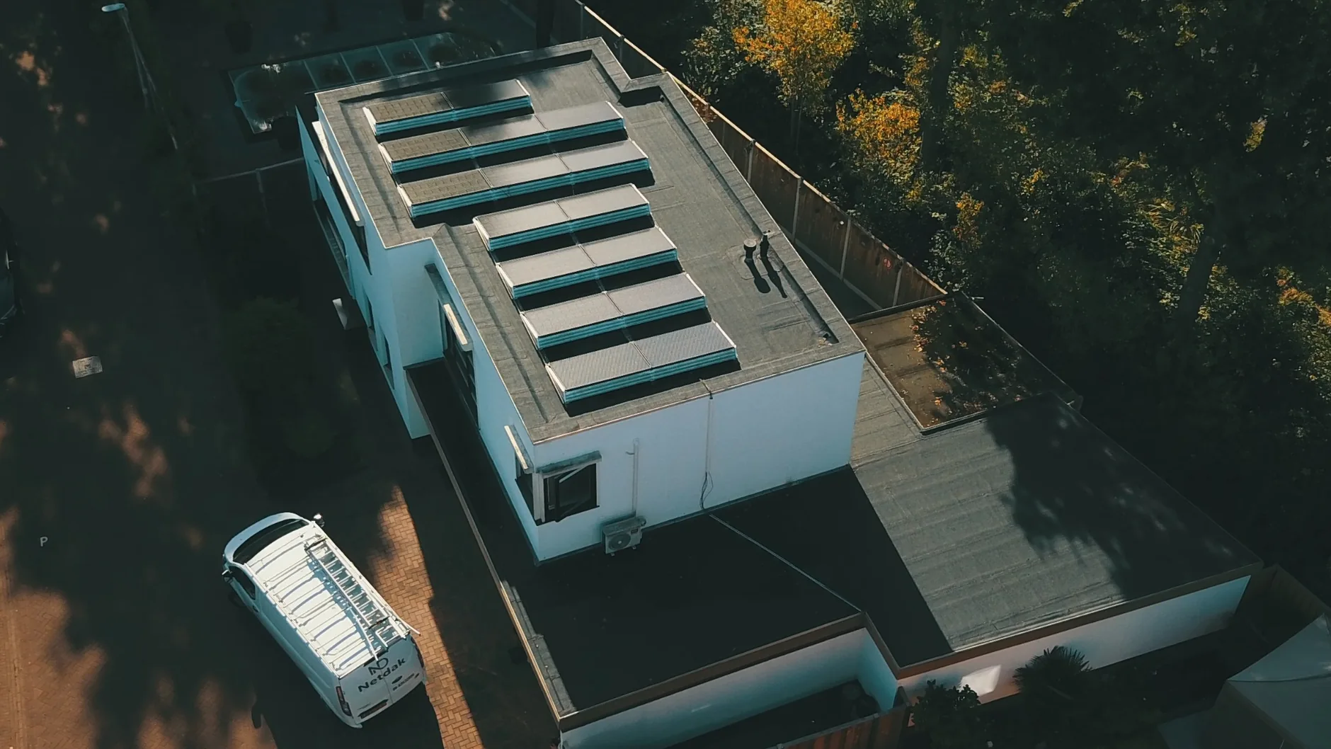 Dronefoto van dakwerk en de Netdak-werkbus bij een uitgevoerd project